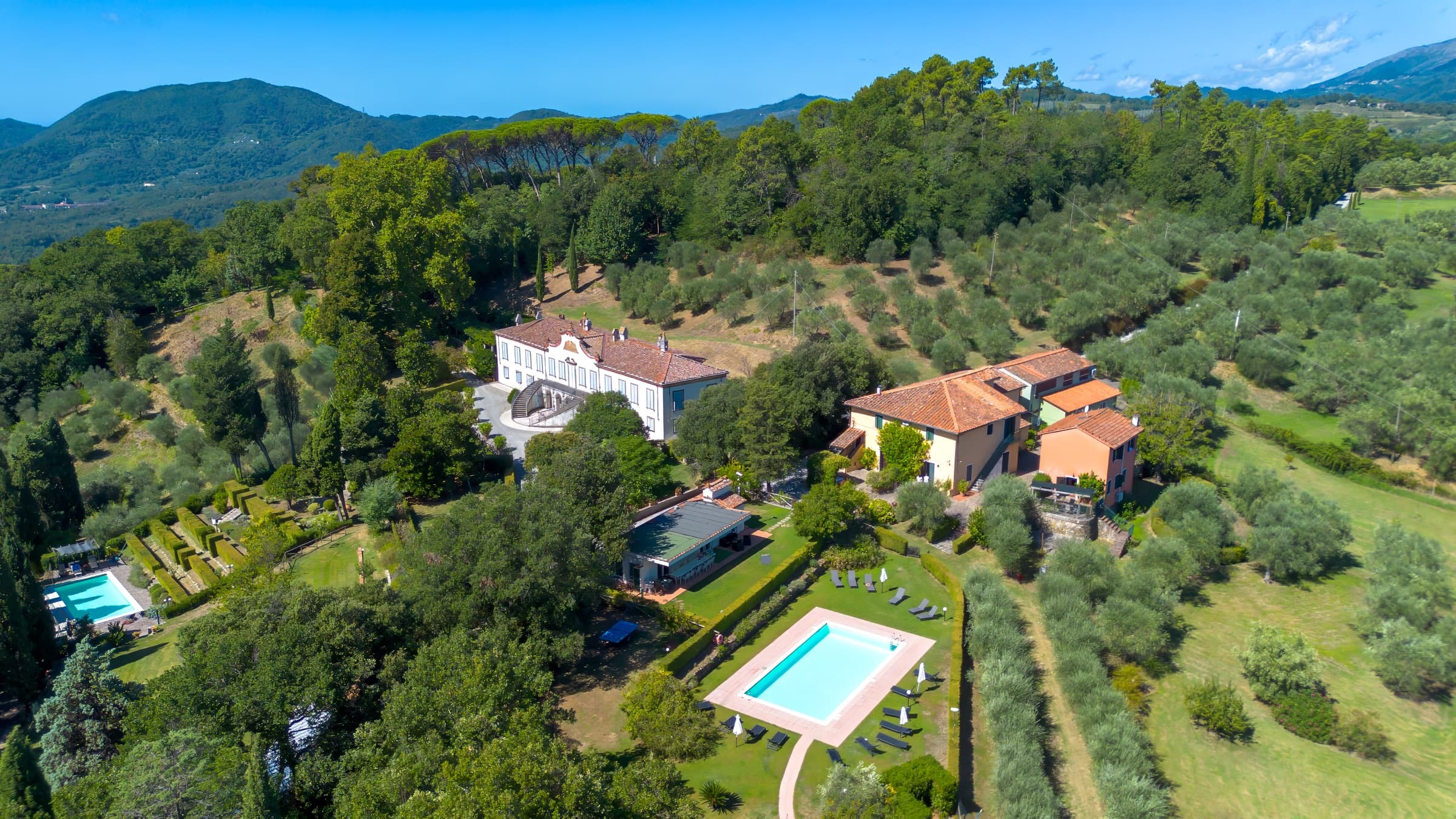 Aerial view of Tenuta Bellosguardo among olive groves and hills above Lucca