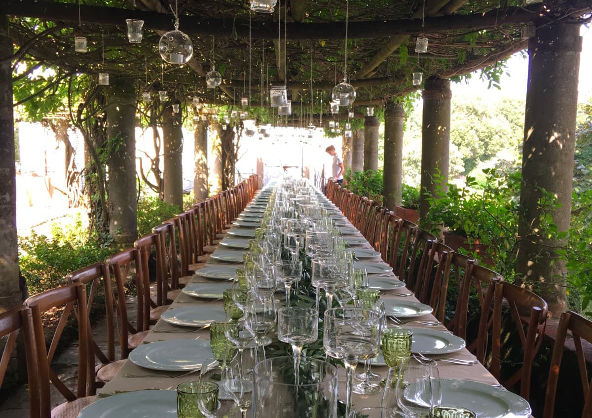 A long table laid under the estate's wisteria pergola